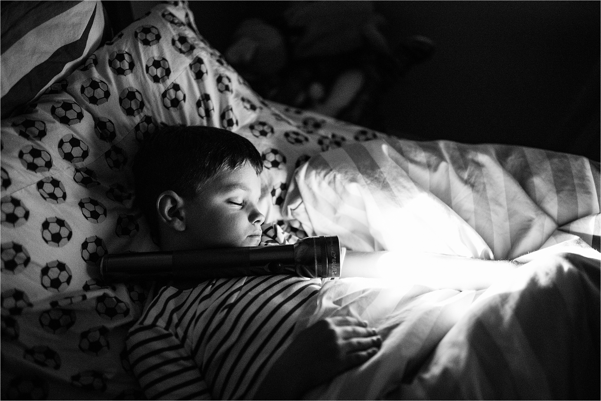 boy asleep with flashlight. 