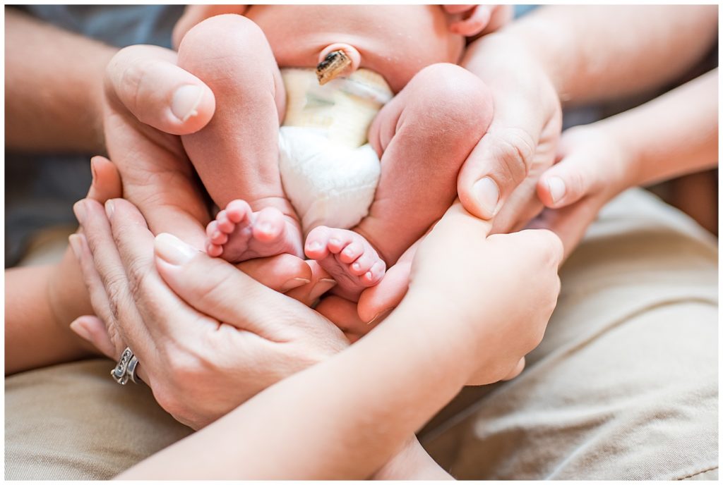 newborn feet and family hands lifestyle session