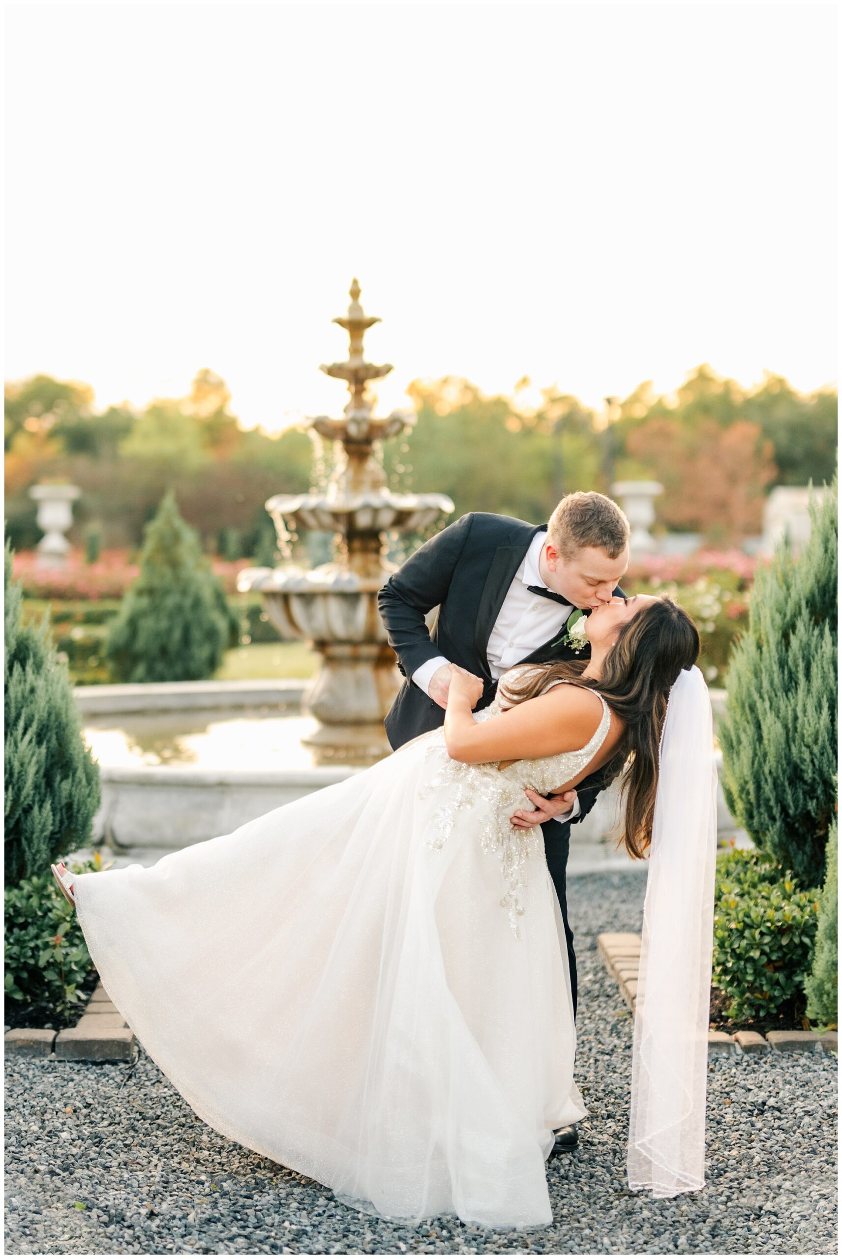 Bride and Groom share a kiss infront of the fountain at Iron Manor.