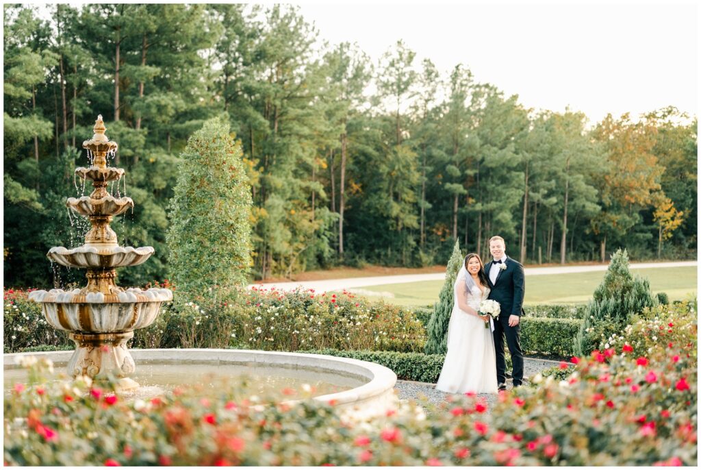 Wedding Portrait of Bride and Groom by a beautiful fountain in the middle of a rose garden at iron manor.