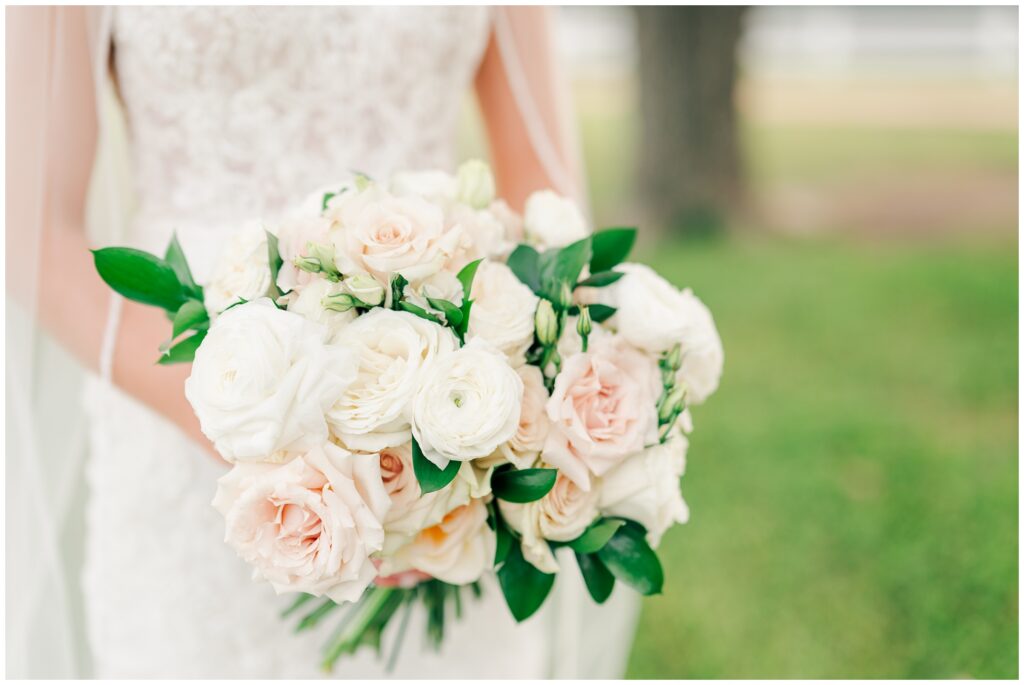 Bride's bouquet of white, cream, blush, and antique roses.
