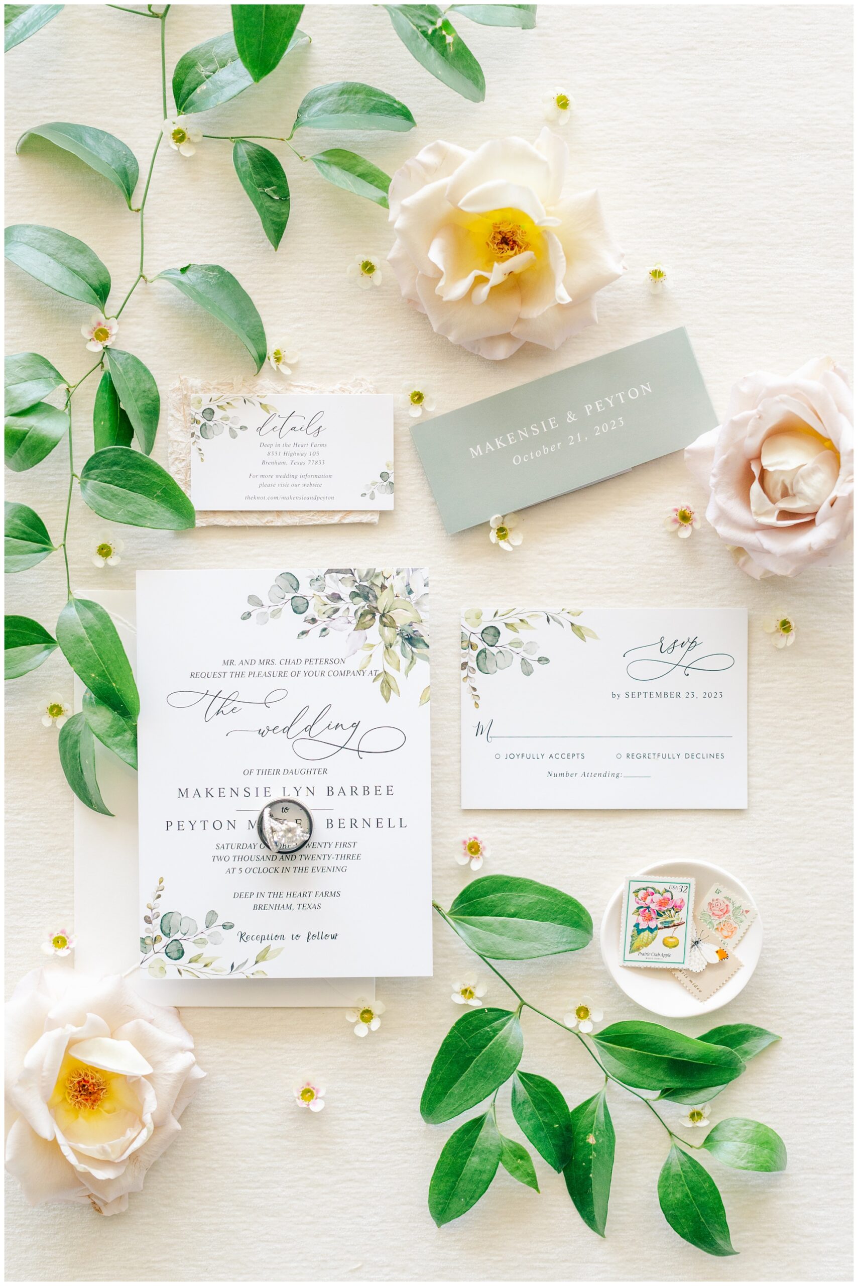 Flat Lay Wedding Invitation surrounded by blush roses and lush greenery.