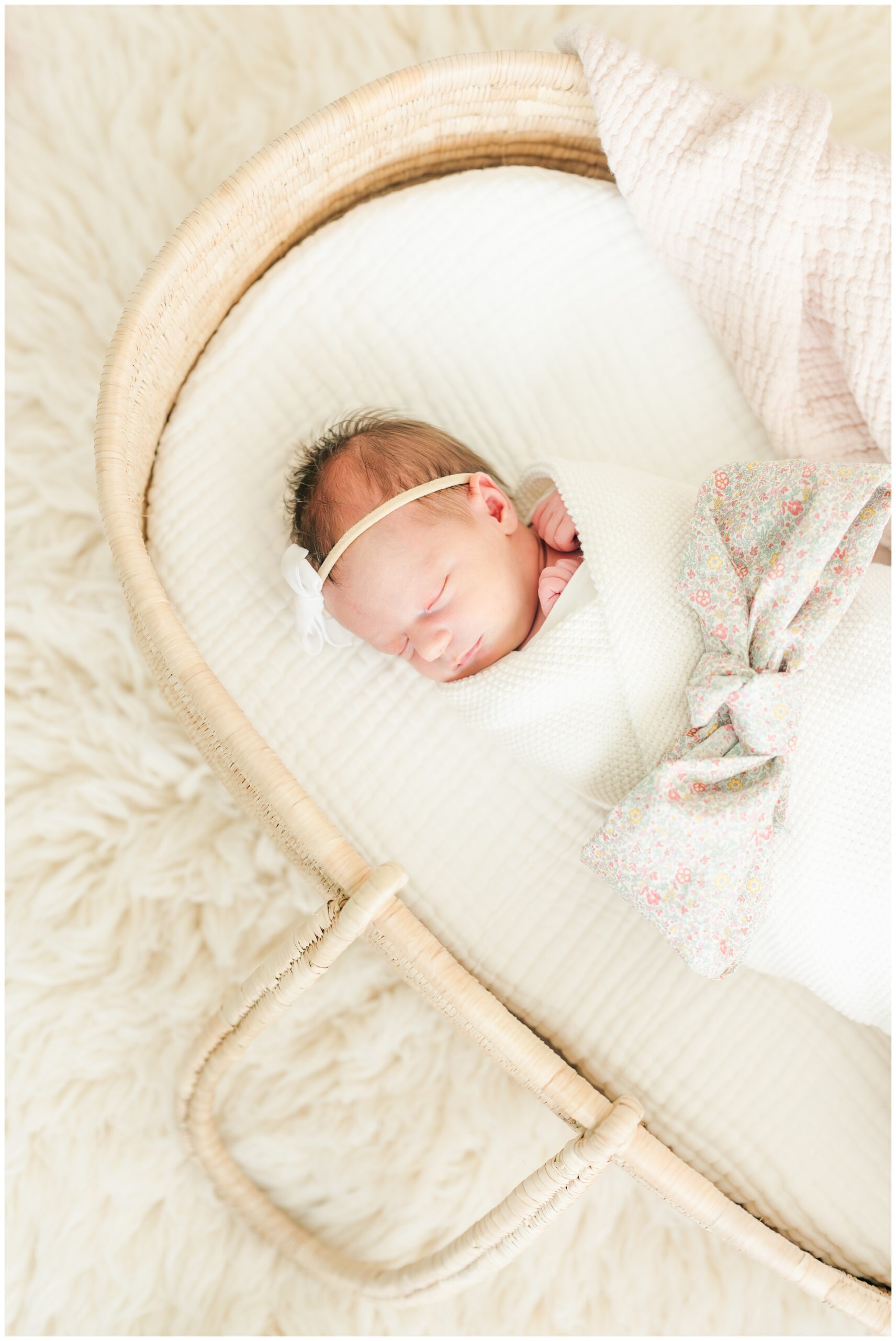 Newborn Photography in The Woodlands, Texas, baby girl swaddled in basket with blanket textures.