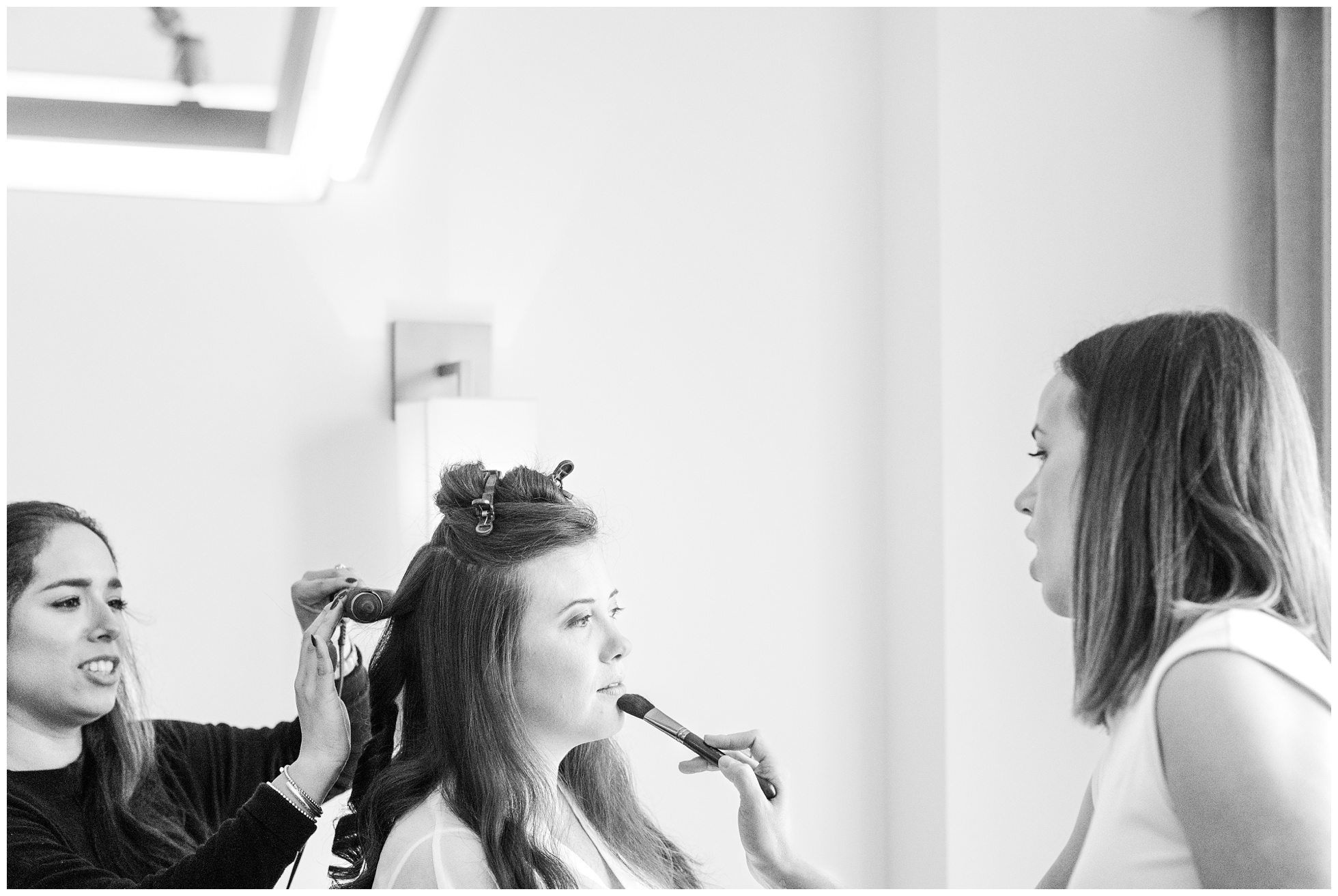 hair and makeup artists work on a bride getting ready at the c.baldwin hotel.
