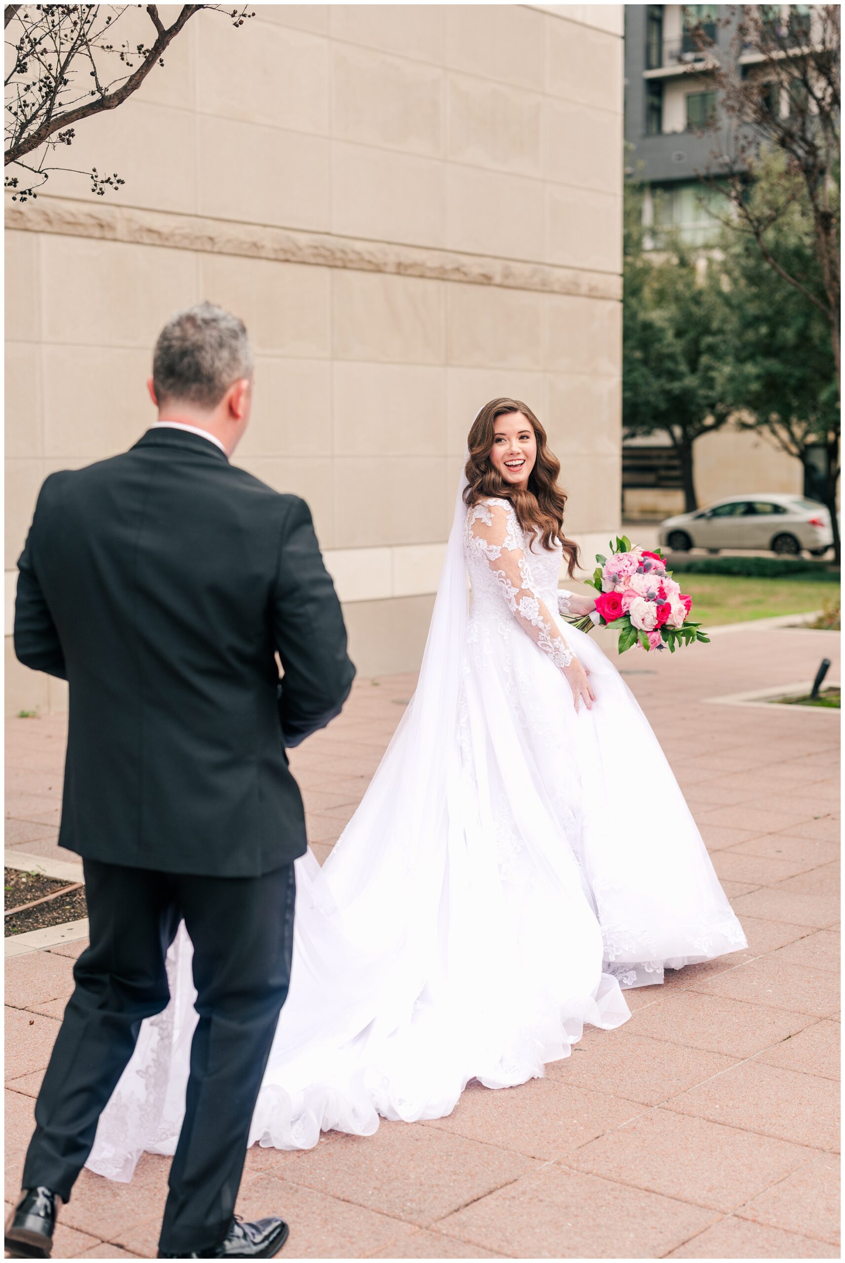 Groom helps the bride with her dress outside the Co Cathedral in Houston.