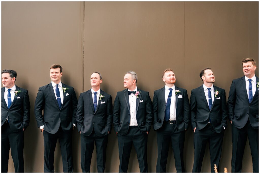 Groom and Groomsmen pose on a wall in downtown Houston.
