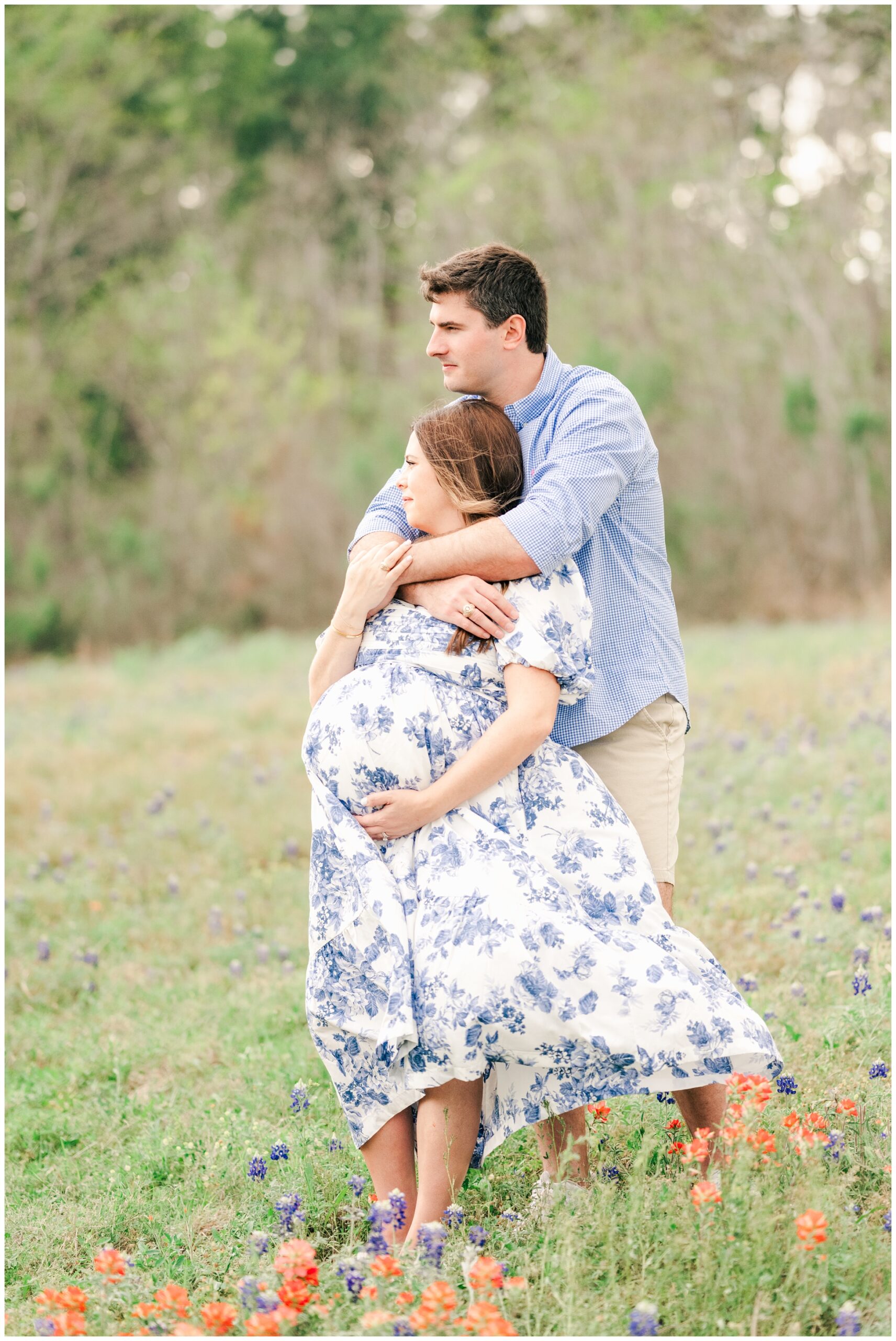 mom and dad wait for newborn baby to be born in a field of flowers The Woodlands.